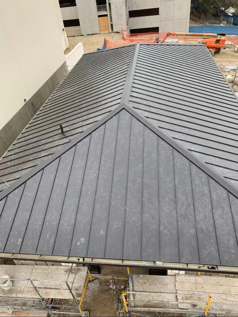 Commercial metal roof construction with crane equipment in Kendall